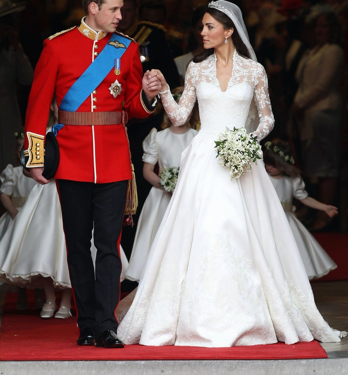 Kate Middleton in her lace Alexander McQueen wedding gown standing with Prince William.
