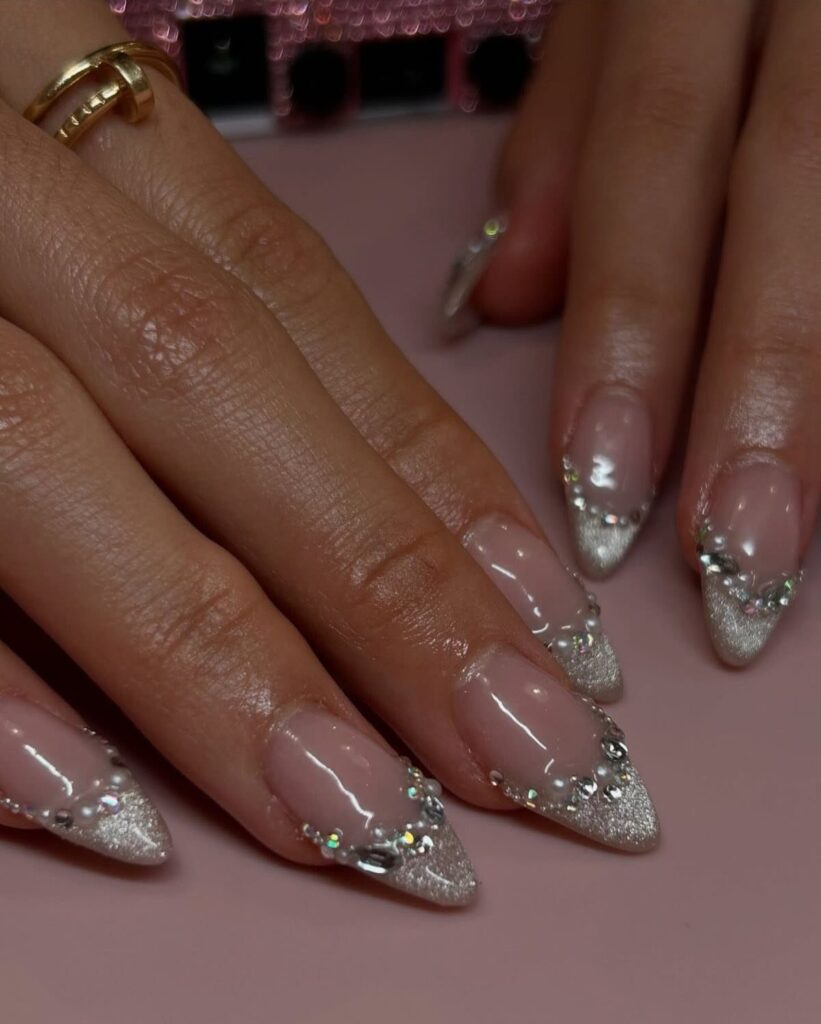 Almond-shaped wedding nails with silver glitter tips and sparkling rhinestone accents.
