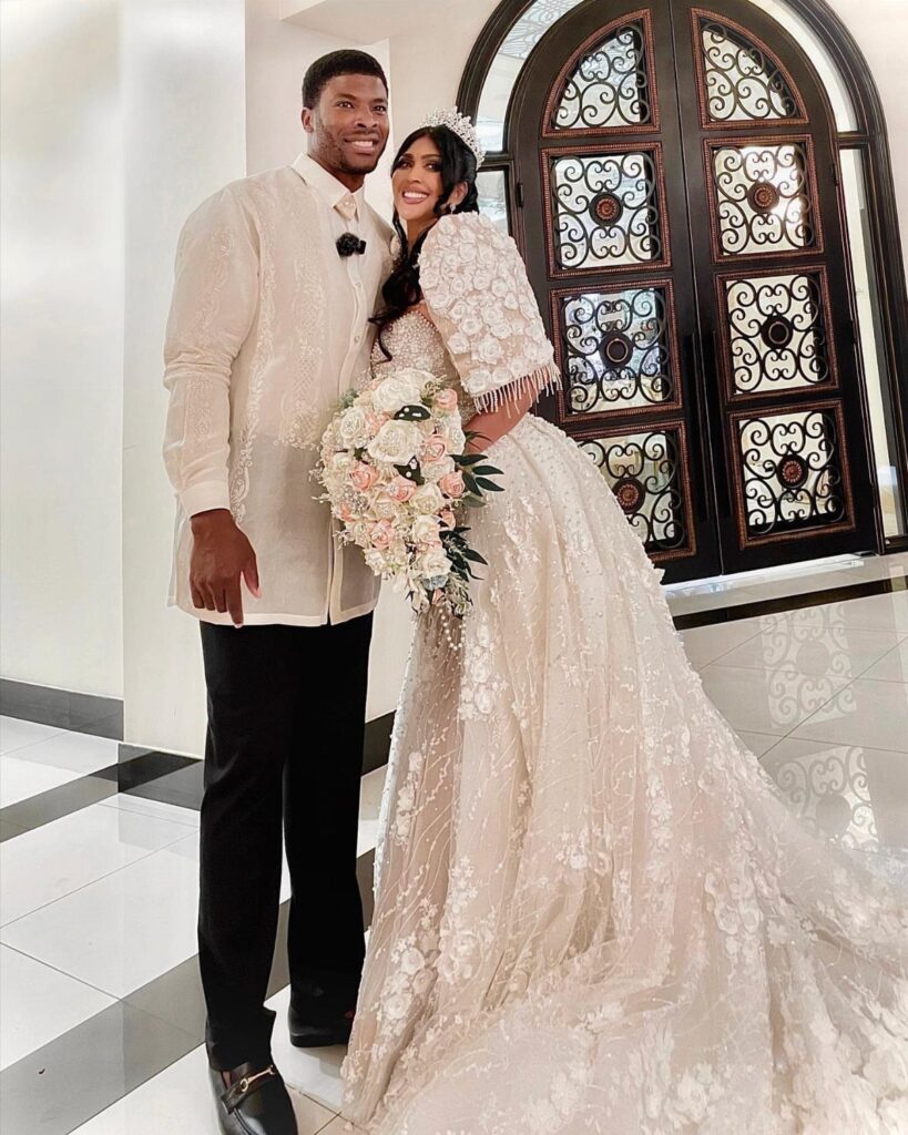 Couple in traditional Filipino wedding attire, featuring a Barong Tagalog and butterfly-sleeved gown.