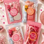 Four pink hangover kits in plastic bags with scrunchies and beauty products.