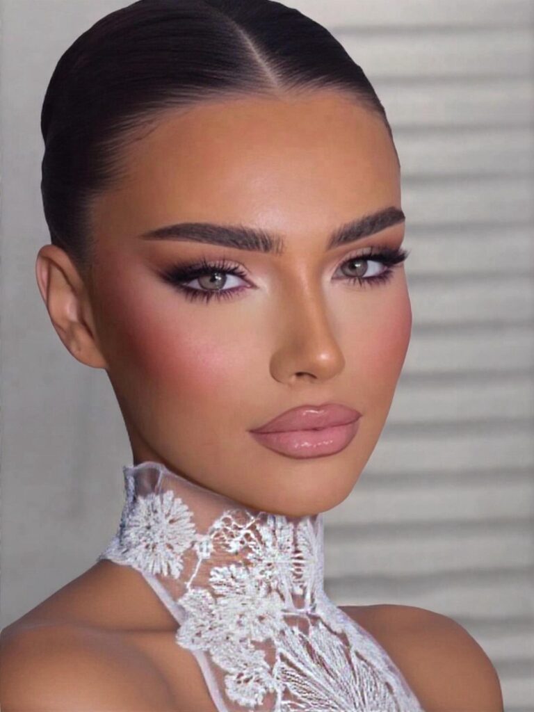 Woman with glamorous makeup and a white lace collar posing for a portrait.