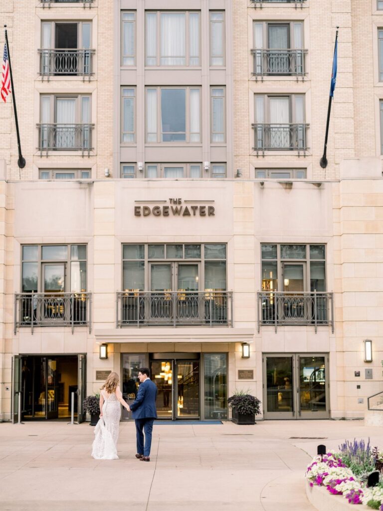 Bride and groom standing in front of The Edgewater hotel wedding venue entrance.